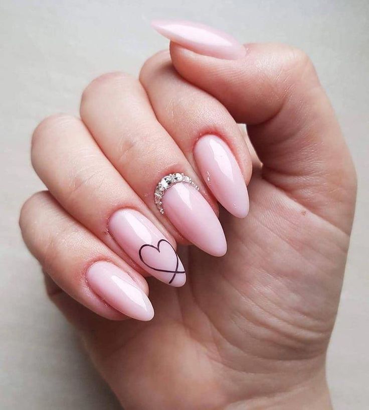 Chic Almond-Shaped Nails in Soft Pink with Black Heart Accents and Rhinestone Sparkle.