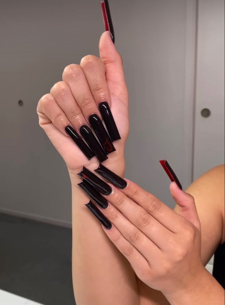 Striking Glossy Black Long Nails with Sharp Edges and Bold Red Accents