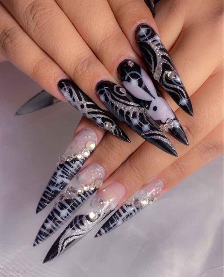 Striking Black and White Nail Design with Silver Accents and Elegant Elongation.