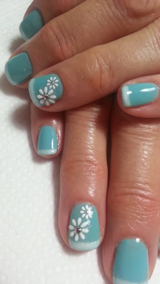 Turquoise Floral Nail Design: A Cheerful Spring Aesthetic with Vibrant Blue-Green and Delicate Whites.