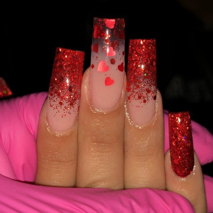 Festive Glittery Red Stiletto Nails with Heart Confetti Gradient.