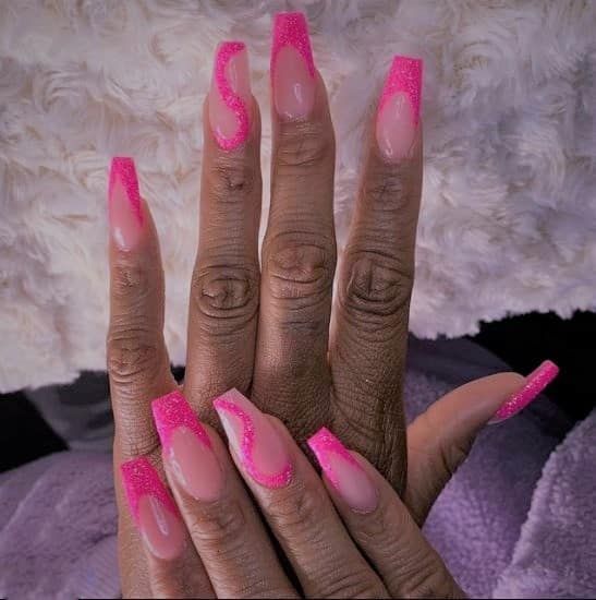 Chic Wave Pattern: Vibrant Pink Nail Design with Glossy and Glittery Finishes.