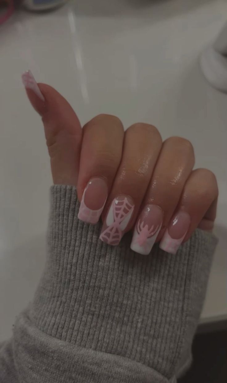 Whimsical Pink and White Nail Design with Spider Motifs for Seasonal Elegance.