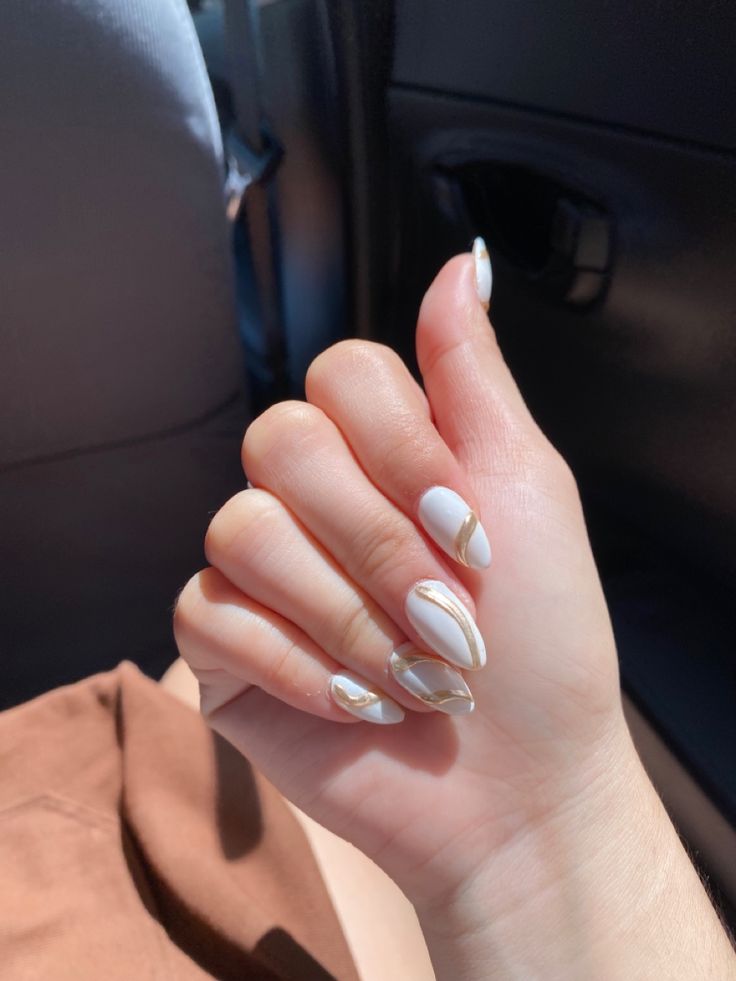 Sophisticated Almond-Shaped Nail Design with Gold Accents on White Base