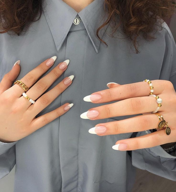 Chic French Tip Nail Design Enhanced by Elegant Rings for Timeless Sophistication.