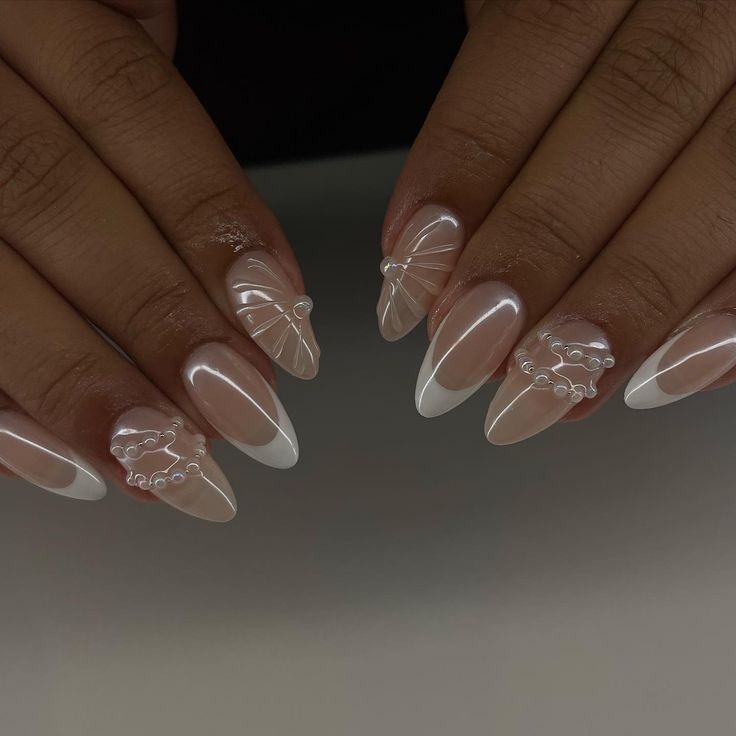 Chic Almond-Shaped Nails: Nude Base with White Tips and Intricate Shell Patterns.