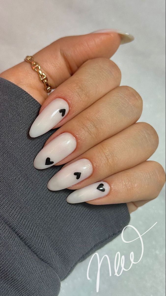 Chic Almond-Shaped Nails with Minimalist Black Hearts on a Muted White Base