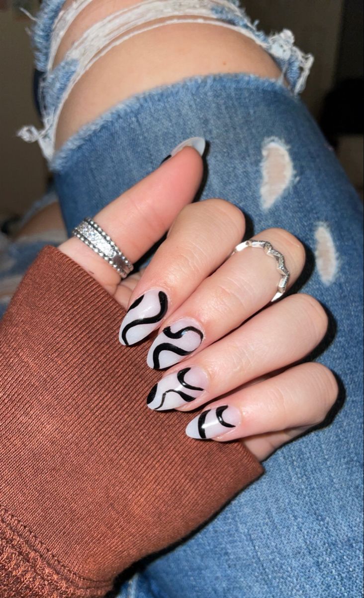 Elegant Nail Design: Soft Nude Hues Meet Bold Black Swirls for Versatile Style