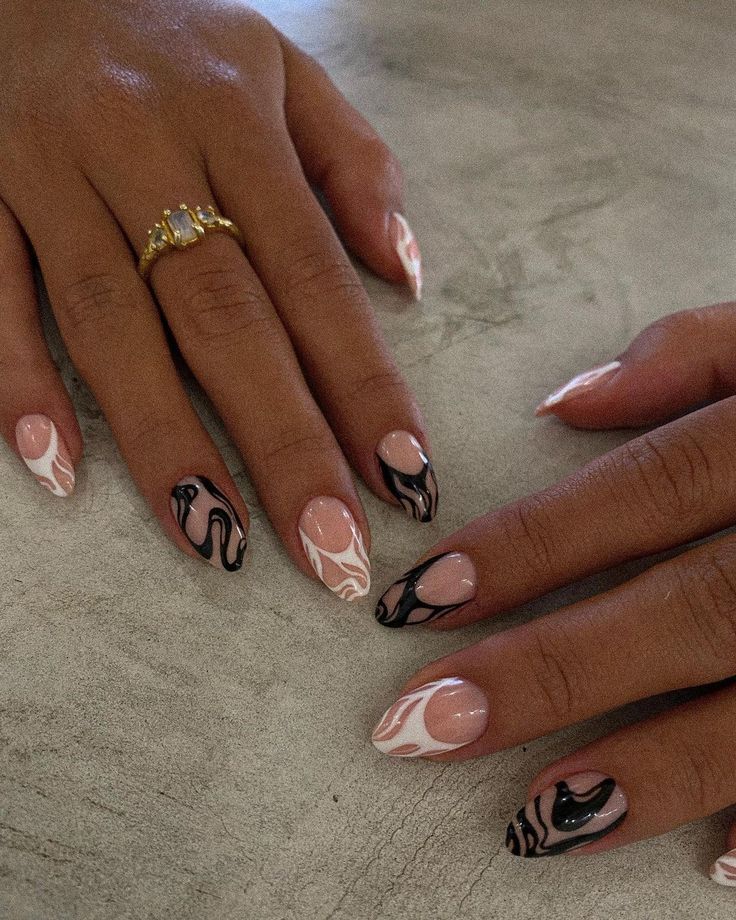 Chic Nail Design: Soft Pink and Bold Black with Swirling Marbled Accents and Gold Rings