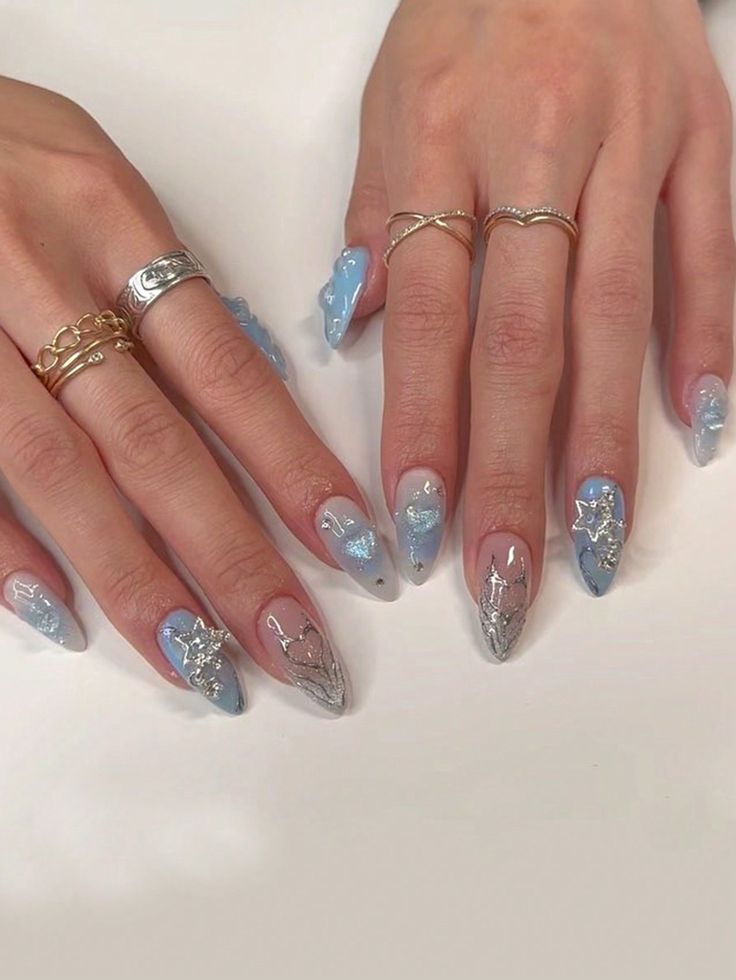 Elegant Soft Blue Nail Design with Clear Accents and Silver Embellishments for a Chic Look.