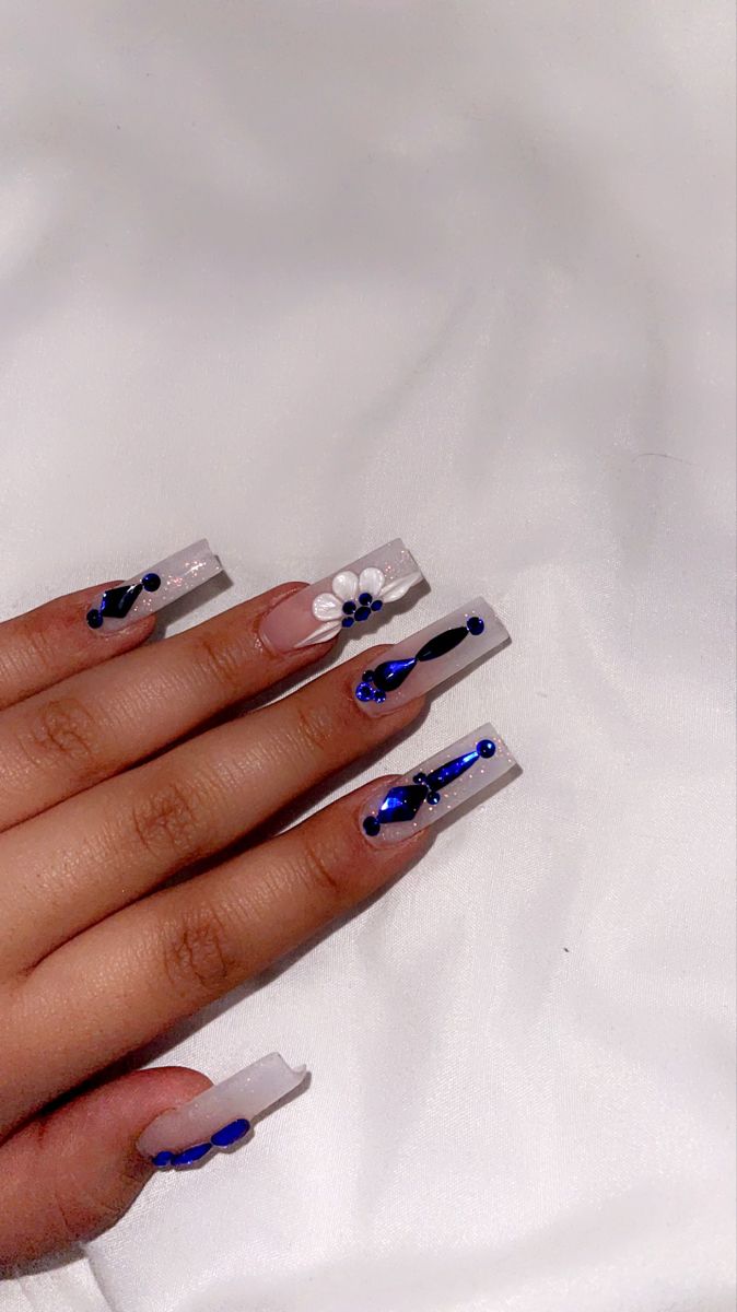 Elegant Elongated Acrylic Nail Design with Abstract Patterns and Floral Accents.