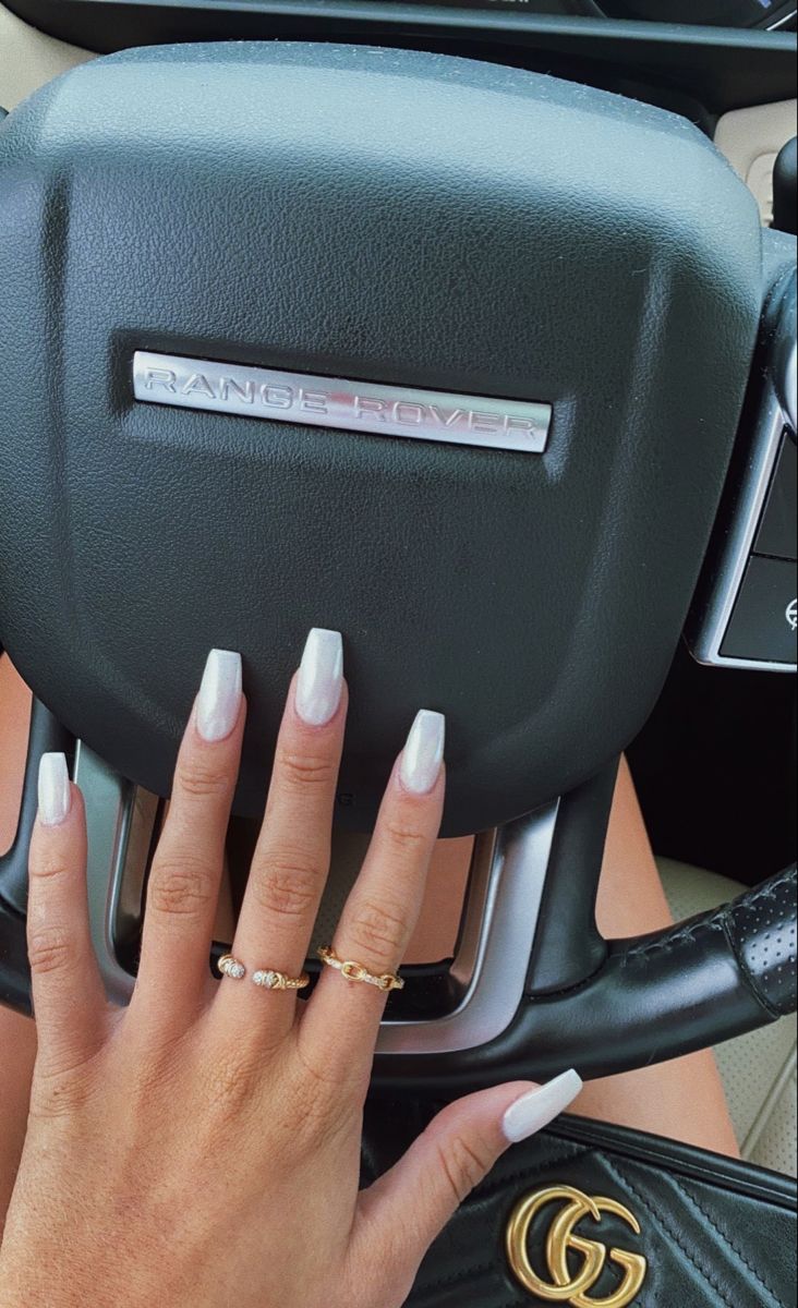 Chic Glossy White Acrylic Nails Enhance Luxurious Vehicle Interior with Effortless Elegance.