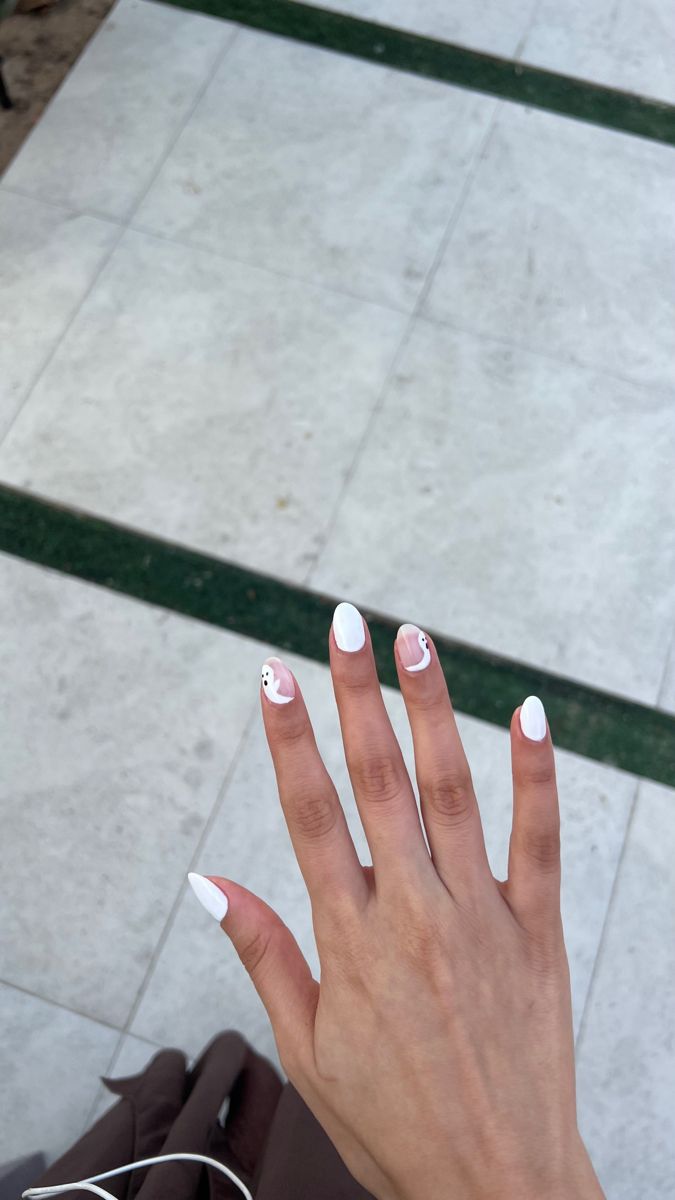 Modern Chic White Nail Design with Playful Accents and Elegant Pointed Tips