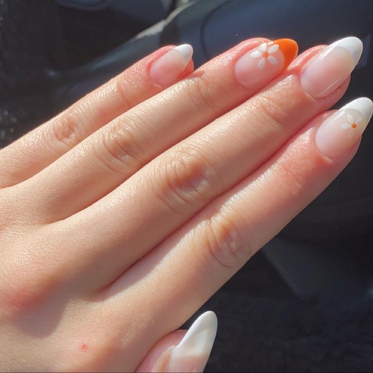 Chic Almond-Shaped Gradient Nails with Floral Accents and Playful Orange Design.