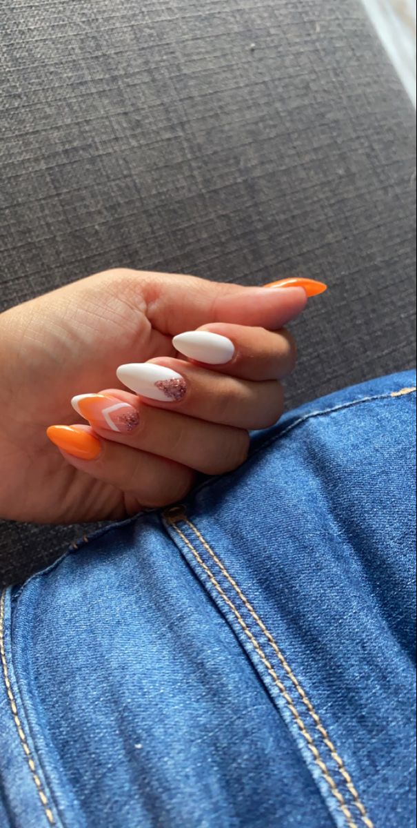 Vibrant Summer Nail Design: Bright Orange and White with Glitter Accent for Bold Elegance.