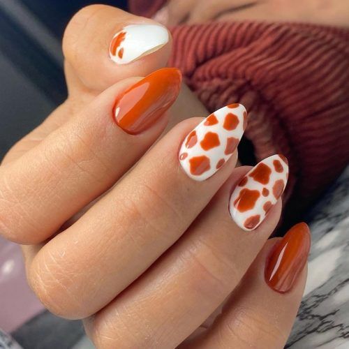 Trendy Orange and White Nail Design with Playful Giraffe Accents.