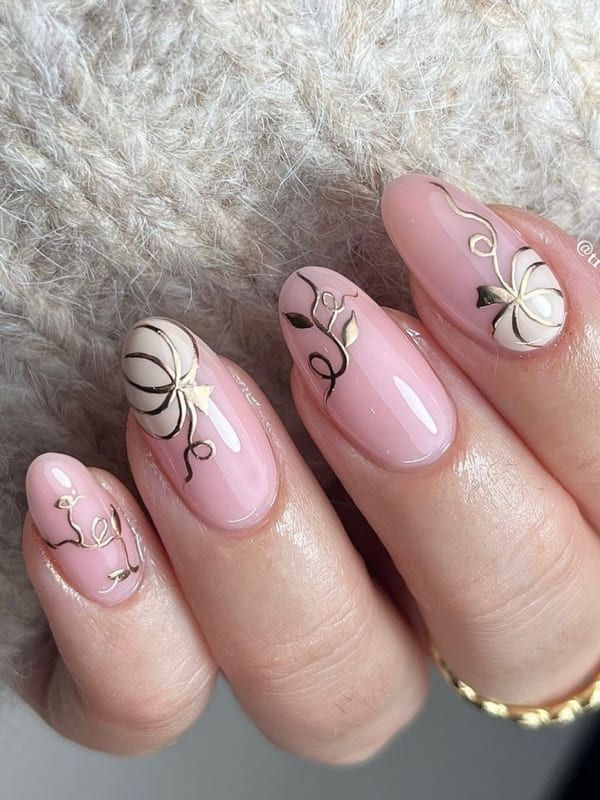 Sophisticated Soft Pink Floral Nail Design with Gold and Cream Accents.