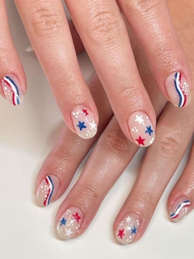 Patriotic Nail Design: Clear Base with Red, White, Blue, and Star Motifs.