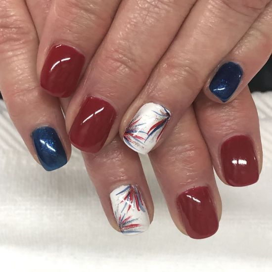 Vibrant Festive Nail Design with Rich Red, Deep Blue, and Striking Abstract Accent.