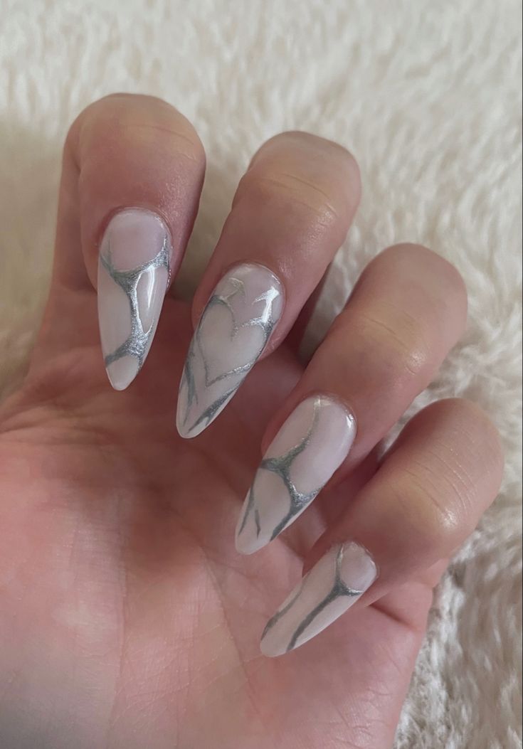 Chic Elongated Stiletto Nail Design with Translucent Base and Intricate Silver Detailing