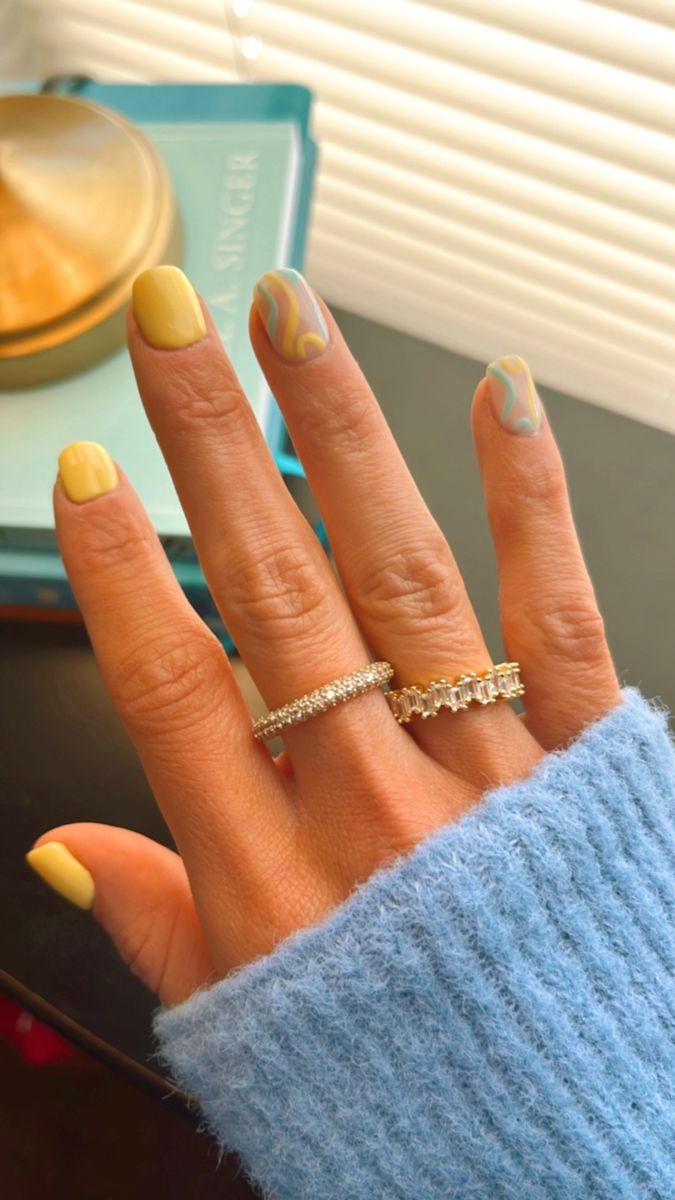 Chic Pastel Yellow Marble Nail Design with Playful Gradient Swirls and Elegant Rings.